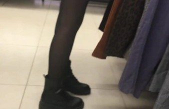 Stranger in black pantyhose in a clothing store