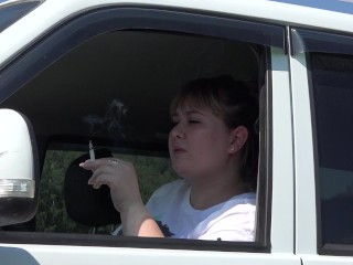 A beautiful BBW with a sexy manicure smokes a cigarette in a car. Fetish